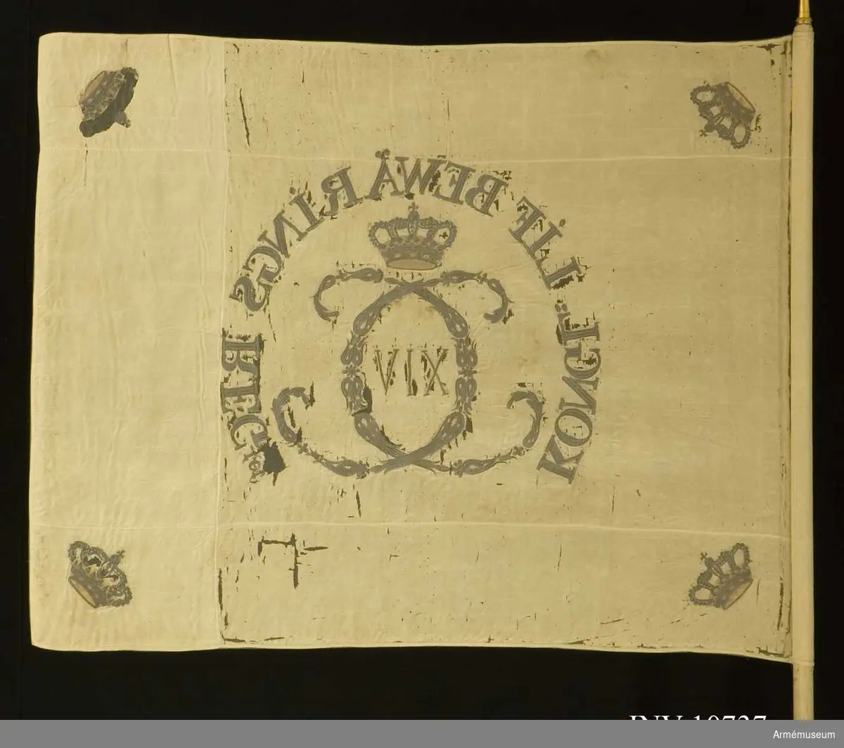 Carl XIV Johans namnchiffer bildat av småornament. I hörnen kungliga kronor.
