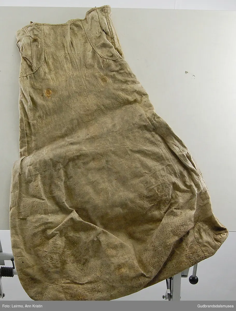Pæreformet skinnpose med smalere åpning. Rester av skinnbånd ved åpningen. Fire smettekroker(?)