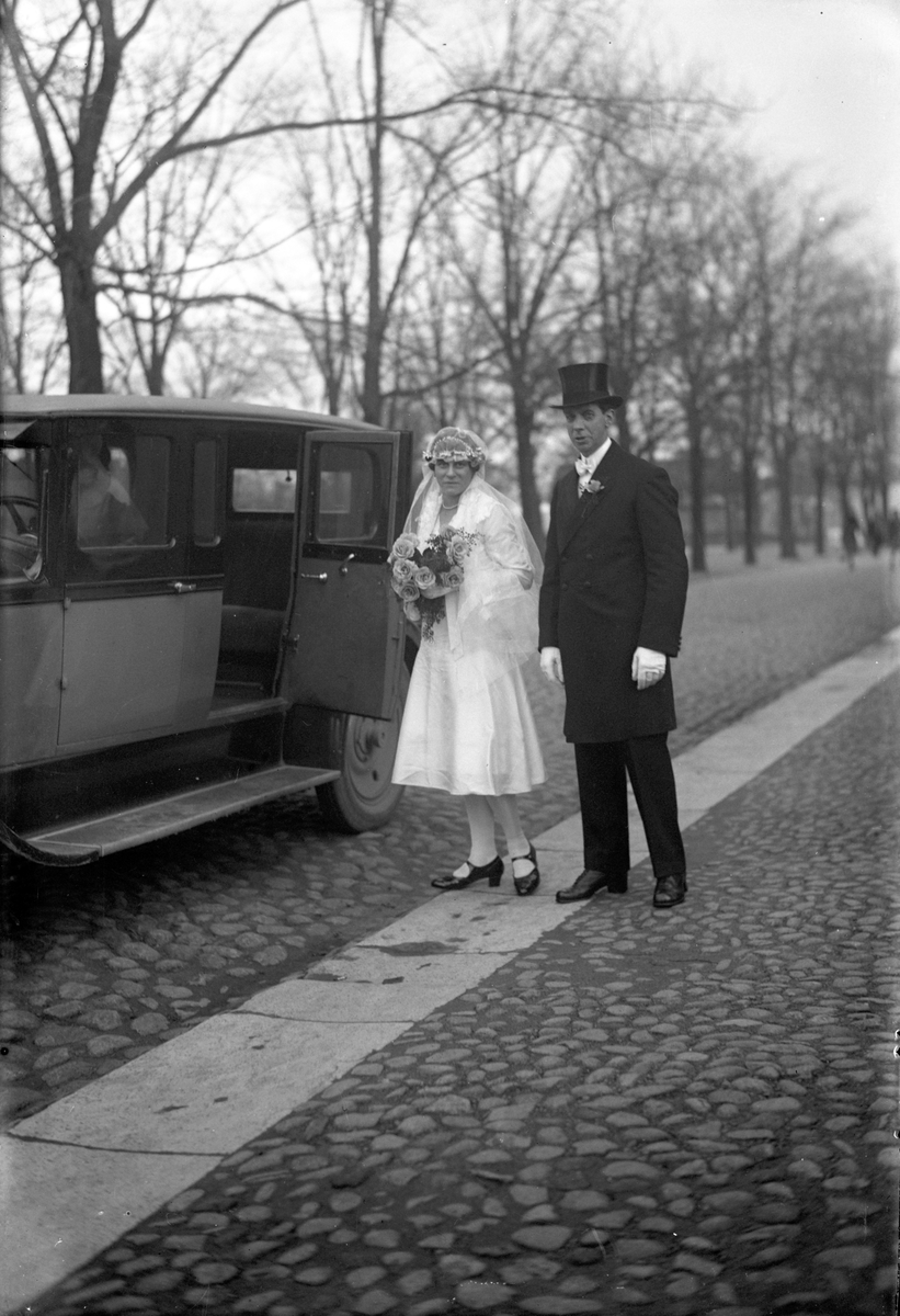 Brudpar utanför en bil på Kungsgatan 3 i Jönköping.
Karl Otto Pettersson född 1889-11-09 i Jönköping och Maria Charlotta Fredman född 1899-08-20 i Norrköping. Vid giftermålet 1929-11-09 antogs familjenamnet Krusing.