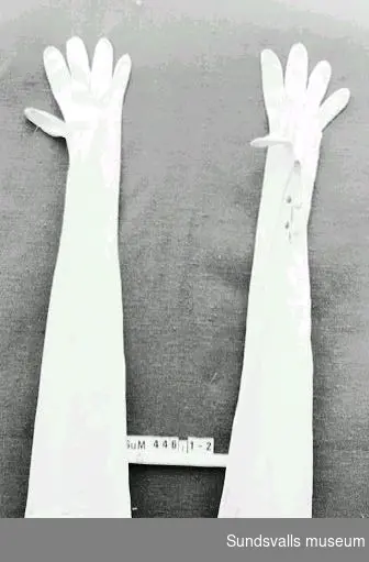 Ett par långa damhandskar i vitt glacéskinn. Storlek 6½. Märkta 'LK' på höger handske och '201213' på vänster.