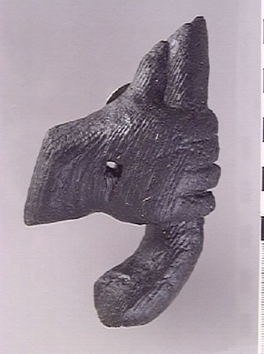 Del av skulptur, högerhand hållande ett horn eller liknande. Handen är bruten, liksom hornets bägge ändar. Fyrkantigt hål genom handen.

Skulpturdelen är relativt välbevarad.