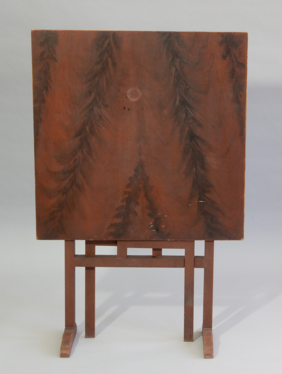 Fällbord av furu med kvadratisk skiva, med två utfällbara ben. Röd och brunmålat med ådringsmålning.