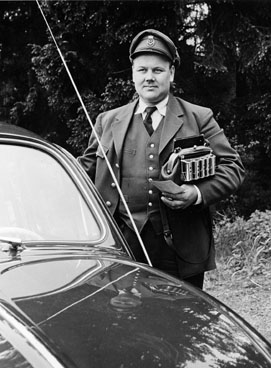 Bilåkande lantbrevbärare Cyril Falk under brevbäringstur.
Cyril Falk på linjen Lönsboda-Hunshult-Björkhult-Lönsboda.

Foto maj 1961.