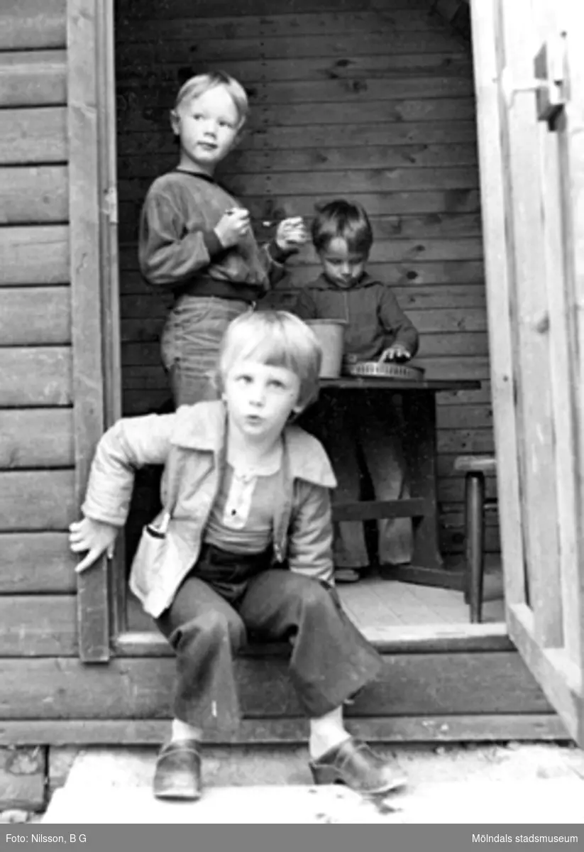 Tre pojkar som leker i en träbyggnad utanför Holtermanska daghemmet 1973.