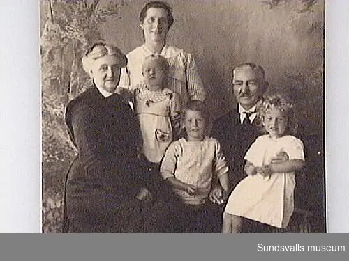 Text på fotografiets baksida: !Sommaren 1921 i Båstad  Jenni Bünsow i randig klänning  Barnen är Karin (ung. 2år), Thorsten (ung. 5 1/2 år, Sigrid (ung. 4 år) Norström".