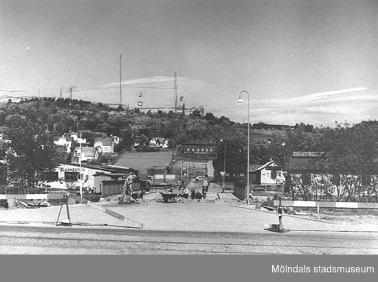 Fredriksgatan sedd från väster, 1940-tal. I bakgrunden ligger stadsdelen Trädgården, Enerbacken och Störtfjället. Till vänster syns Mölndals Glasmästeri och till höger en liten stuga som hade en skylt som det stod Mölndals Mekaniska på. Ännu längre in till höger låg LMC, Lantbrukarnas Mjölkcentral. Huset fick därefter logistikföretaget Bilspedition som hyresgäst.