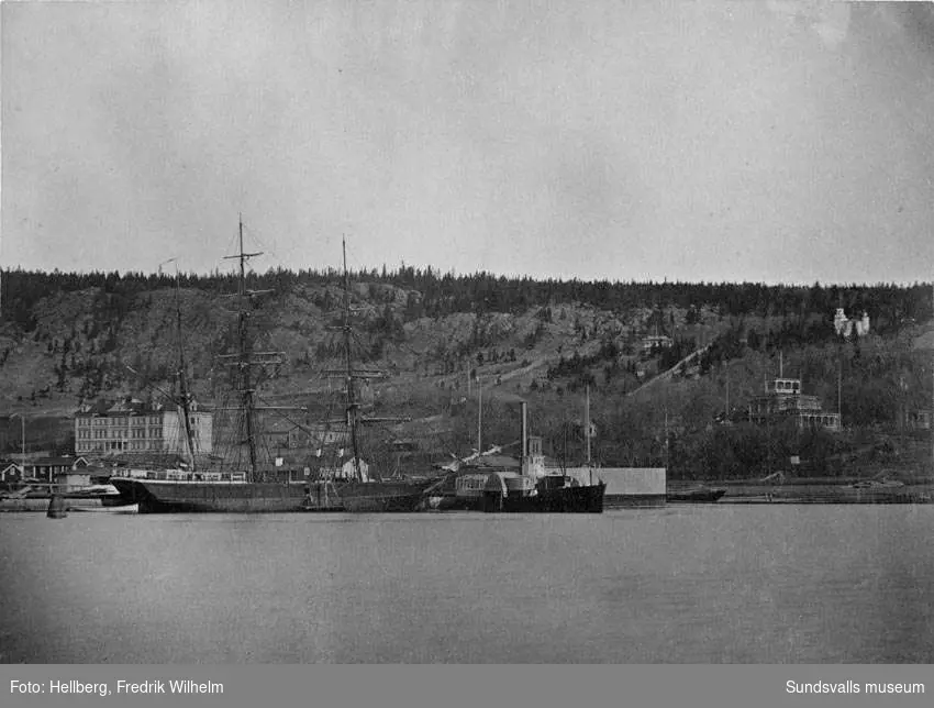 Hamnen med ett  segelfartyg och hjulångaren "Swartvik". På bilden till vänster Sundsvalls lasarett,  i mitten på bilden bakom hjulångaren syns ett torn vilket hör till kallbadhuset och till höger på bild syns Tivoli. Bildtext i allbum "Hamnen, Lasarettet, badhuset och Tivoli i bakgrunden."