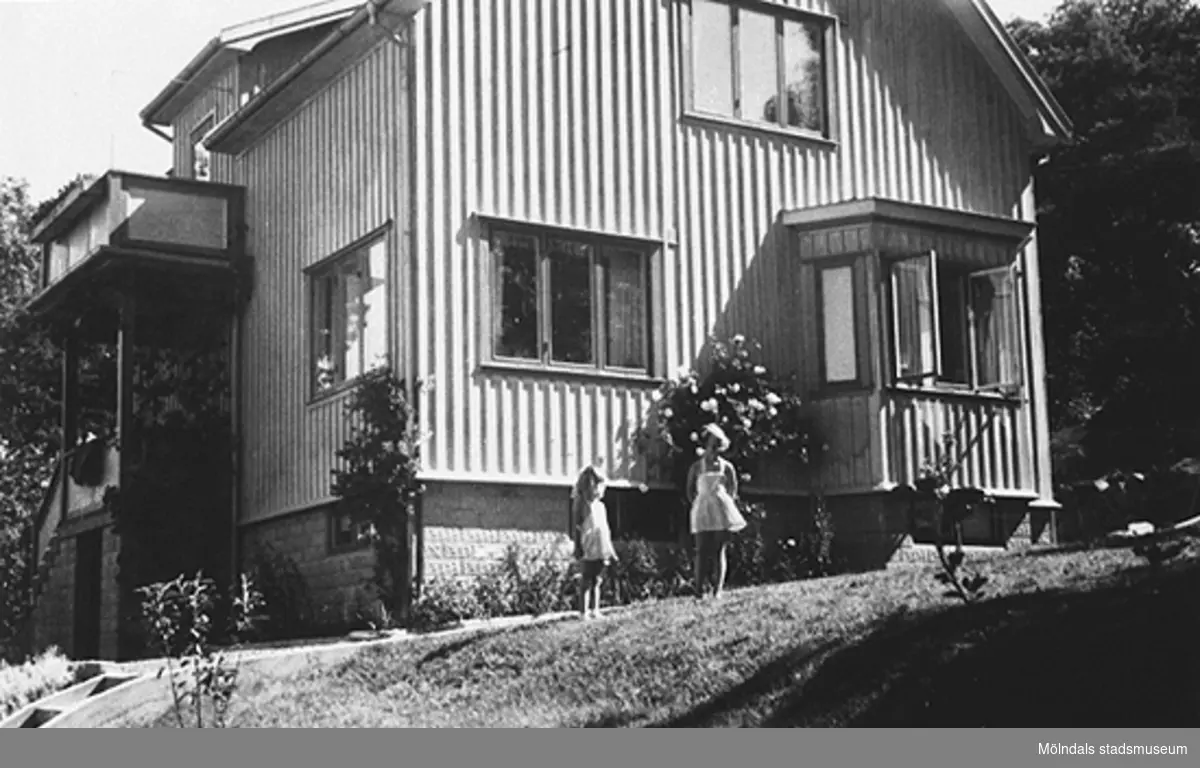 Systrarna Eva (gift Kempe) och Karin Pettersson (gift Hansson) står utanför sitt föräldrahem på Gamlehagsvägen 17 i Torrekulla, år 1951.
