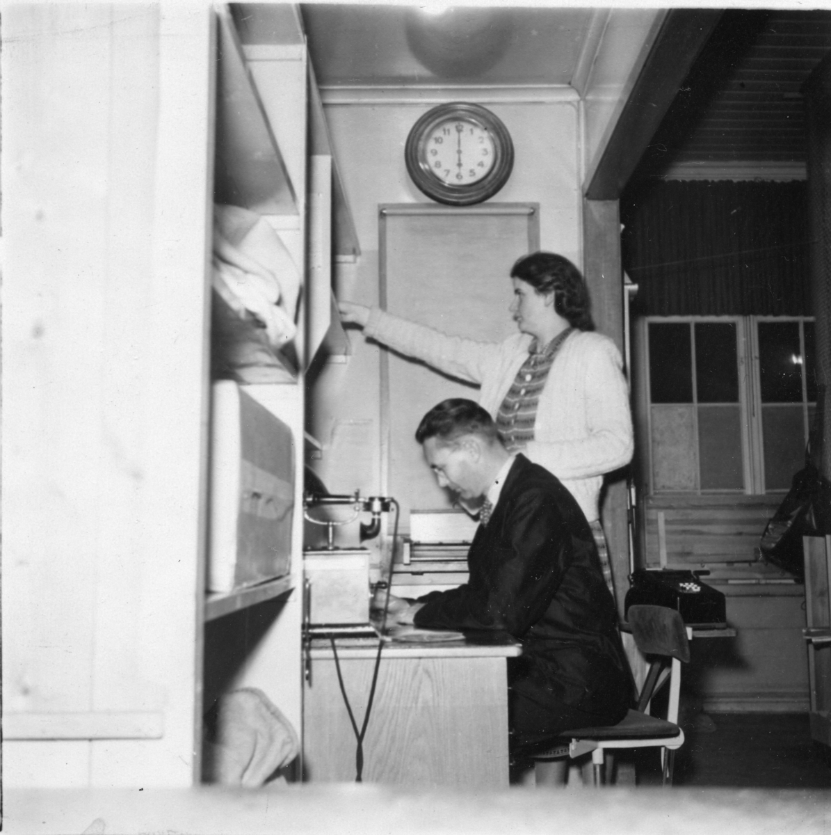 Poststationen i Habo, Västergötland. Sista dagen i den gamla lokalen den 3 november 1949. Stationsmästare Bergmer och postbiträdet Mary Fogelström.