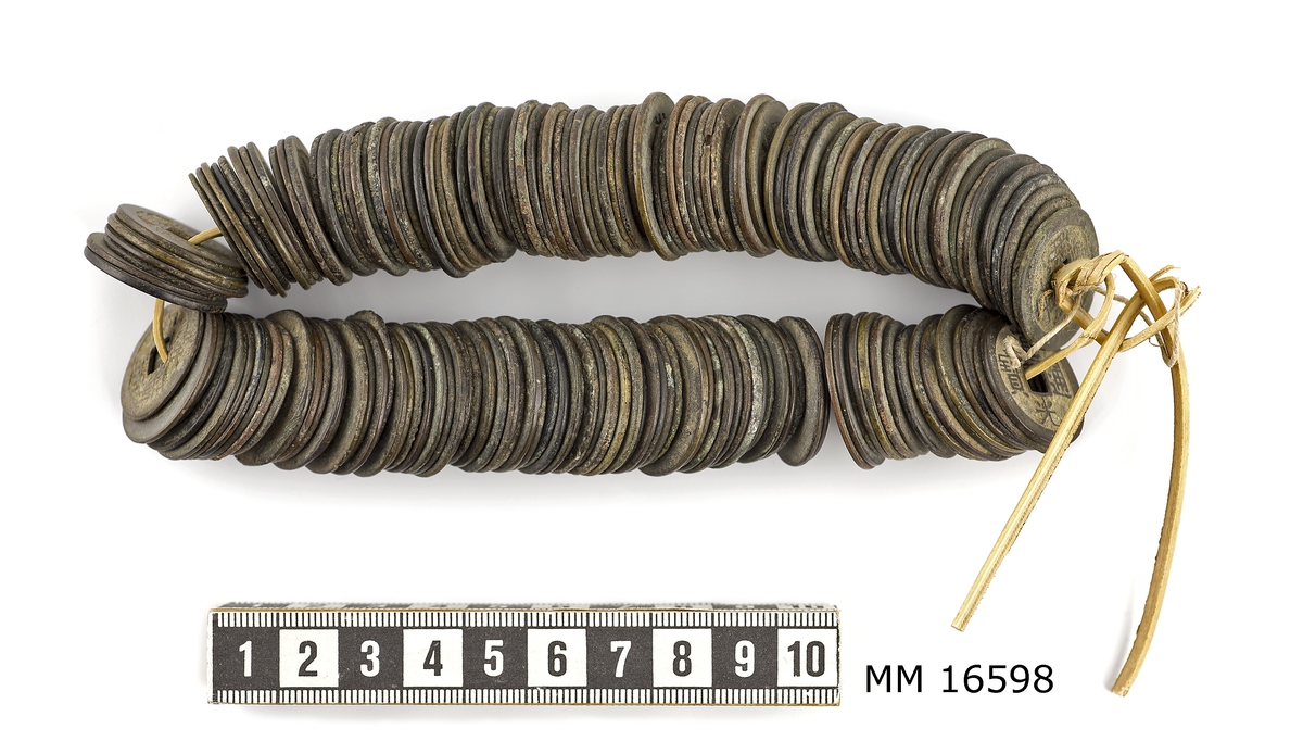 Mynt, kinesiska, chienmynt (eller cashmynt). Bambusnöre med uppträdda mynt av brons. Mynten är olika stora och olika välbevarade.