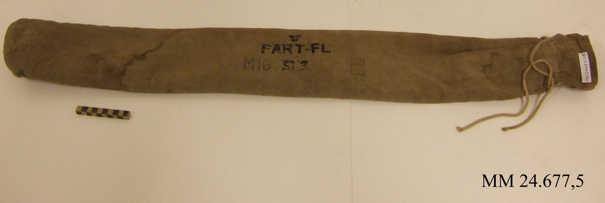 Påse av kraftig, beige kanvas. cylinderformad med öppning som stängs med snöre. Påsen märkt: "tre kronor", "FART-FL ST 3" "M16".
