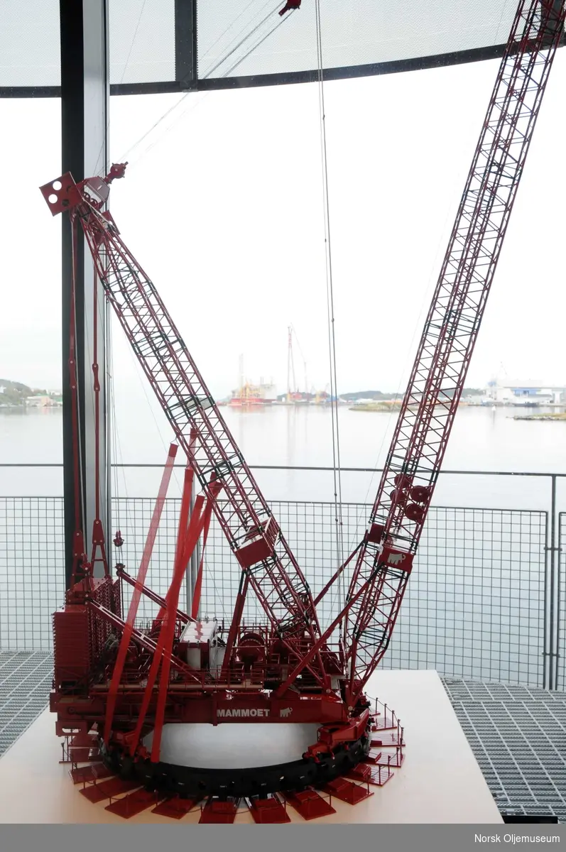 En modell av verdens største mobile krane - Mammoet PTC - står utstilt på Norsk Oljemuseum i en periode mens originalkranen er i arbeid på Yme-plattformen, som ferdigstilles ved Bergen Group Rosenberg Verft i Stavanger (i bildets bakgrunn). 