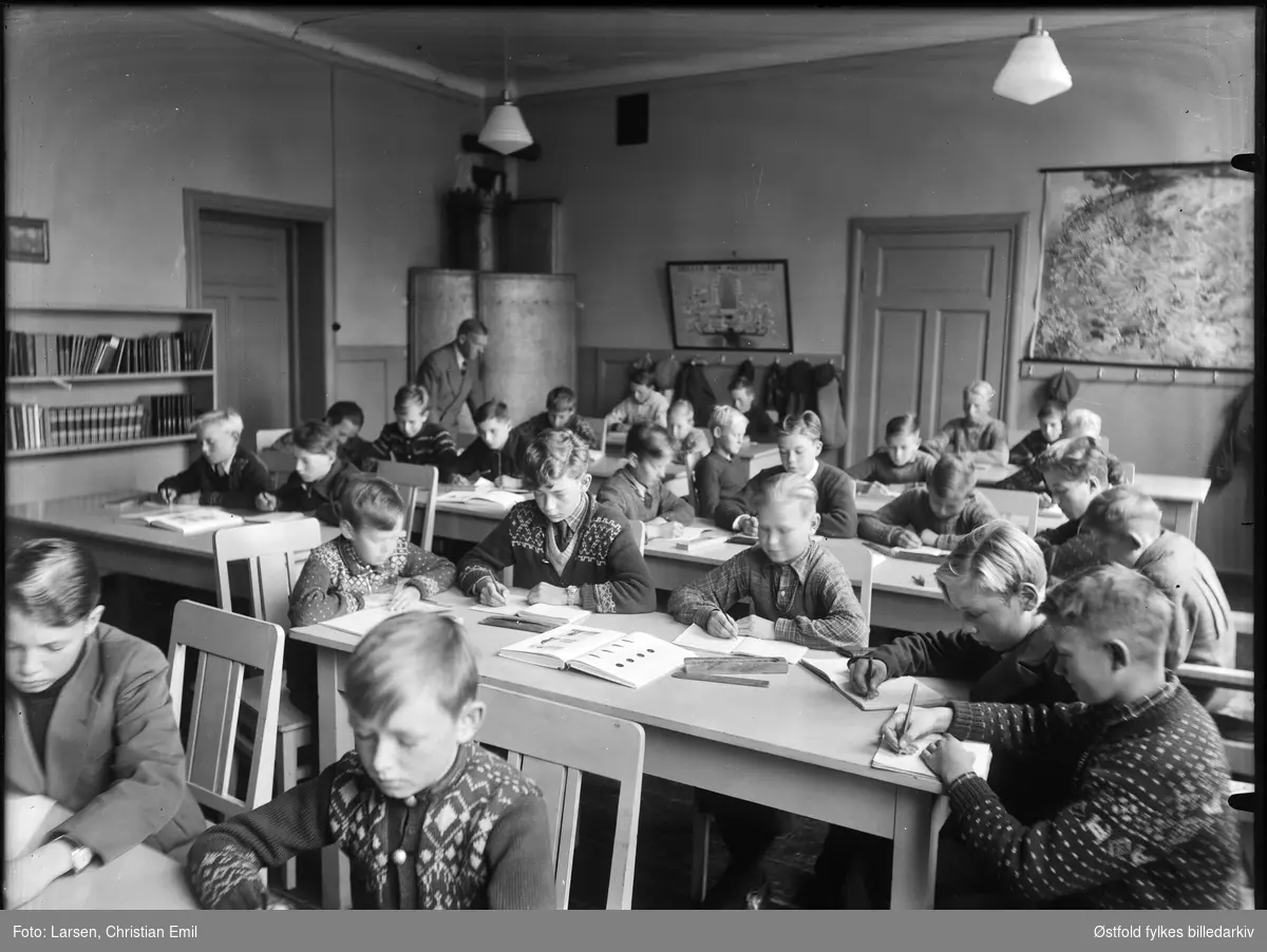 Ukjent skoleklasse med gutter i Sarpsborg-disktriktet. Interiør fra klasserom.