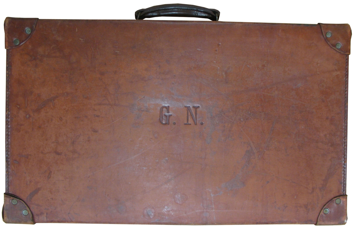 Resväska i brunt läder. På sidan finns på sidan G.N. , ägarens initialer.

Resväskan användes av järnhandlaren Georg Nyström (1874-1957), Vänersborg, vid handelsresor till Tyskland under 1920-talet. Han gjorde flera resor då man kunde inköpa varor för nästan ingenting i det krigshärjade Tyskland.