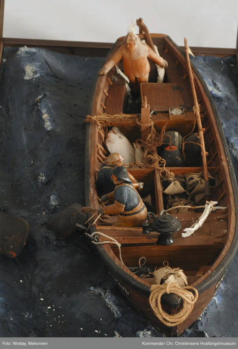 Modell av fartøy, åpen båt til kveitefiske, dory, montert i "sjø". Modellens monter er ikke inntakt.
