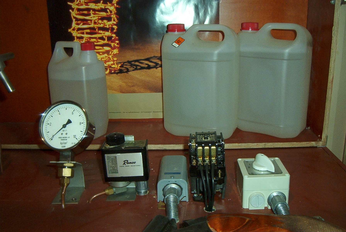 Stort HB-apparat. Tanken er innebygd i en kasse av kryssfinér og hengslett lokk. På instrumentene som hører med står det: Bergs Maskin, Trondheim kp/cm2, Ranco, Trade mark registered, Penn. En stor sikring og en bryter 0-1-2. 3 kanner med "sprit".
