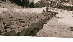 Demning bygges? To mann i arbeid.
Elveforbygning i Tuddal.