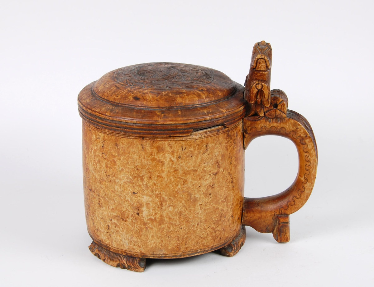 Kanne av dreid valbjørk. Lokk med akantusskurd. Løveformet lokkåpner. Hank med bladranke. Tre løveføtter.