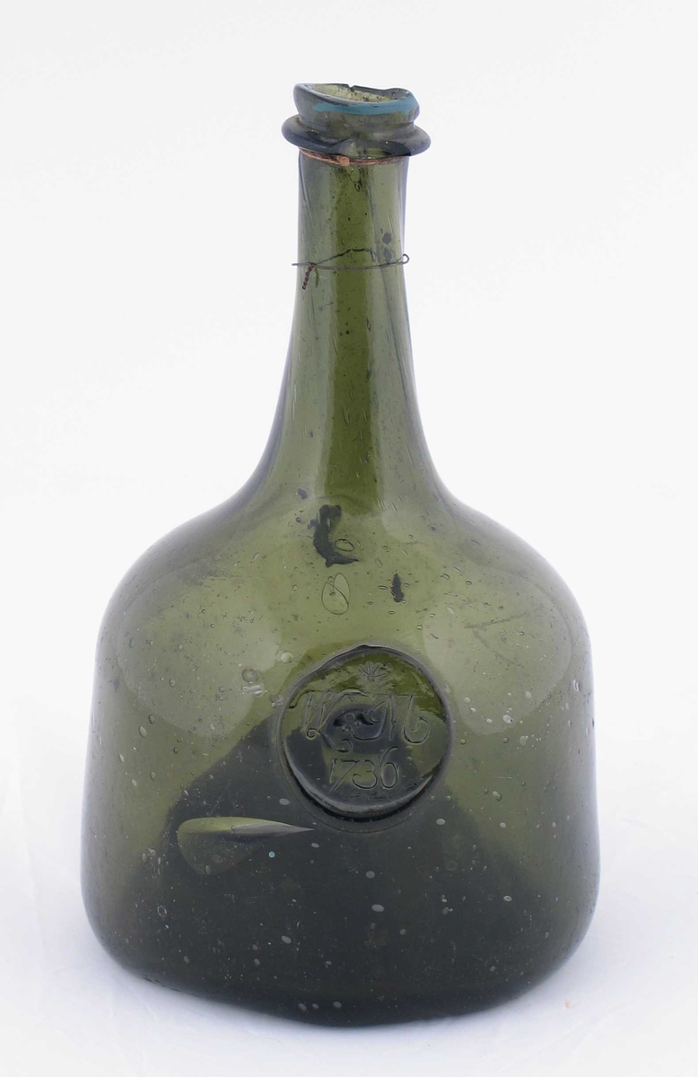 Grønn flaske med stempel på utsiden. Den første initialen i stempelet, W, er usikker.