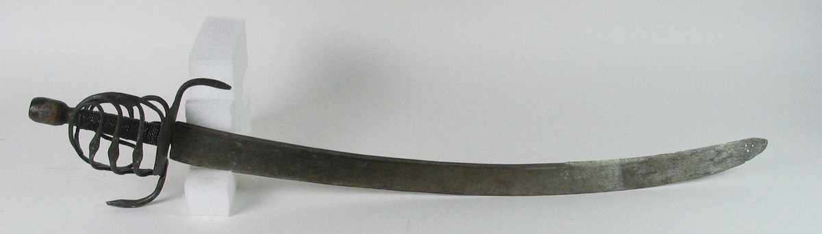 Rund tønneformet knapp i tre. Asymmetrisk feste med tre sidebøyler som har fortykninger på midten på utsiden og tommelbøyle og to sidebøyler på innsiden. Nyreformede parérplater. S-formede runde parérstenger med fortykkede avslutninger på endene. Fremre parérstang er nyere.
Tregrep med jerntrådvikling.
Enegget krum kline med smal ryggstillt blodrand. Smedmerke på venstre side. Klingespissen er dekorert med tre små hull.