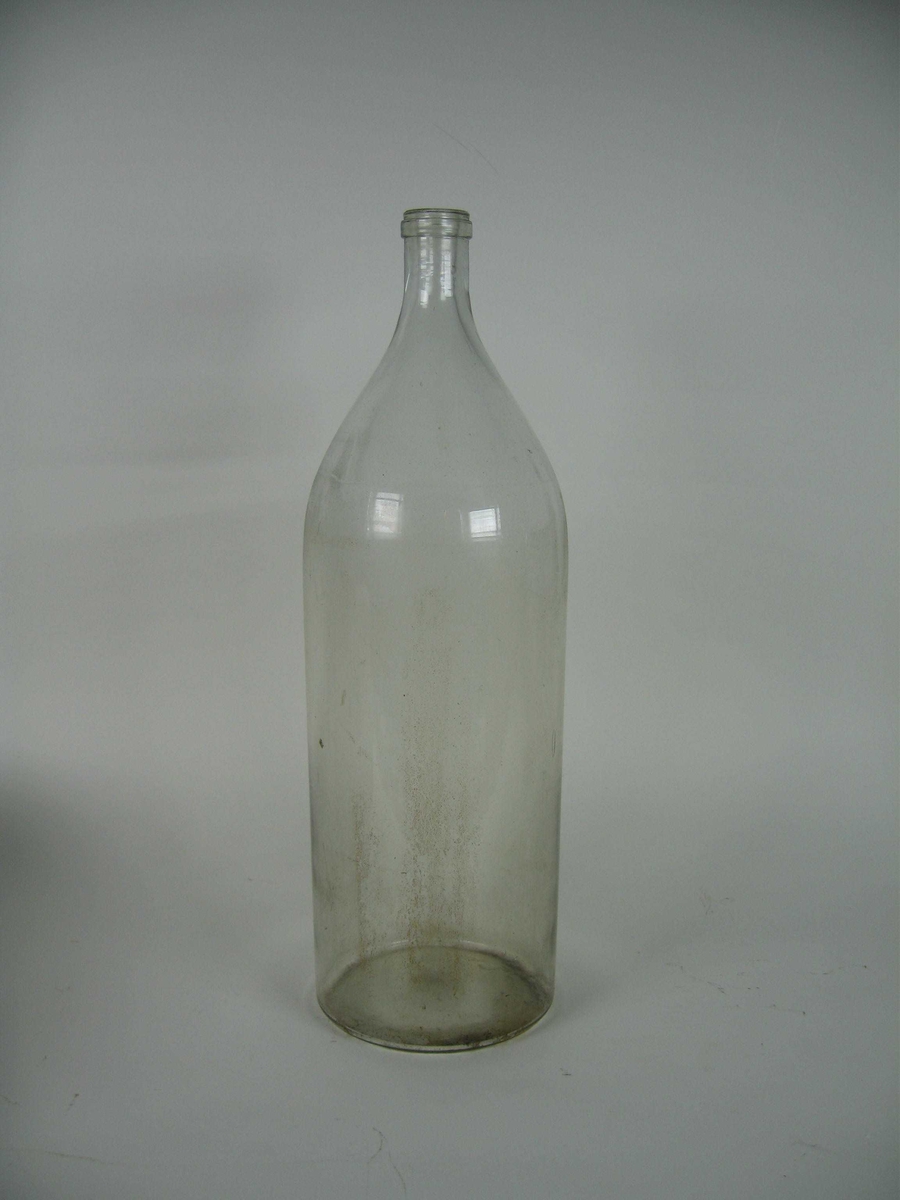 Stor sylindrisk flaske med smal hals. Laget av klart glass, til bruk med kork.