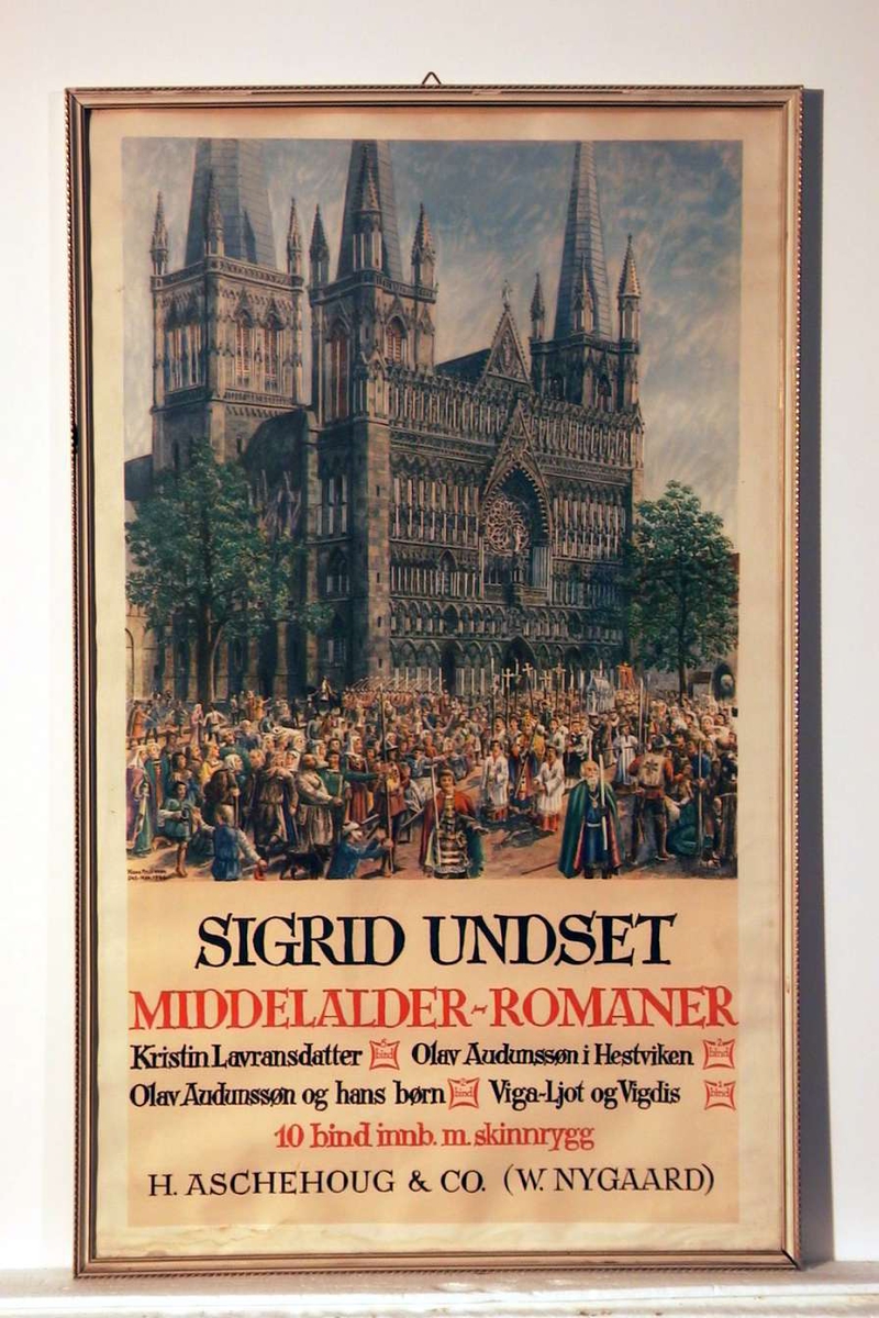 En innrammet plakat som reklamerer for S.U.s middelalderromaner, innbundet med skinnrygg. Motivet på plakaten er et religiøst opptog (Olsok?) foran vestfronten av Nidarosdomen. Rammen er hvit med forgylling.