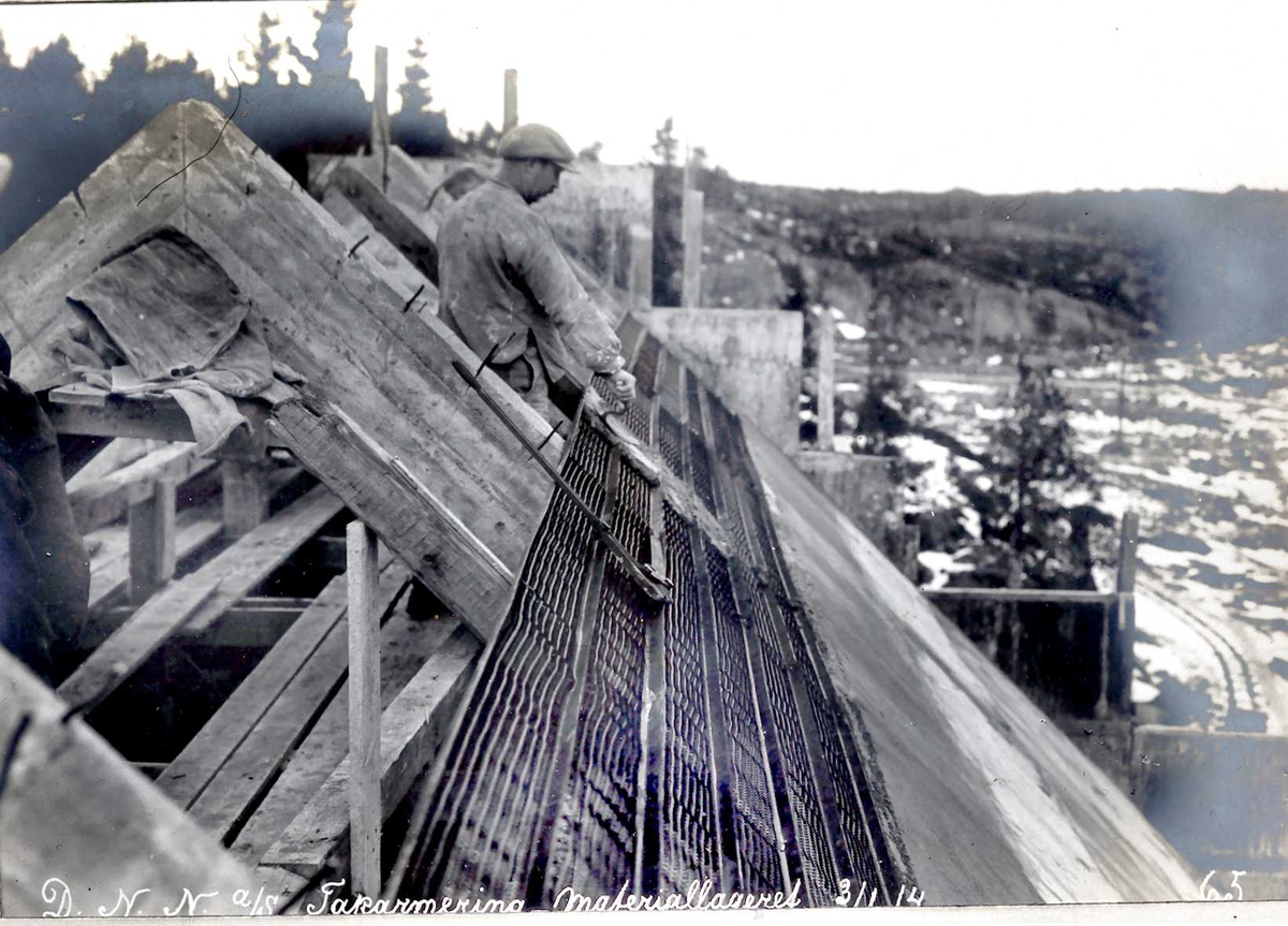 "03/01-1914" Nitriden, forskaling og armering av takkonstruksjoner for bygning for materiallager, verksteder og kontorer. Fabrikktomten til høyre.