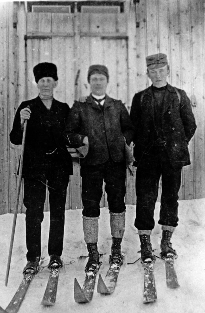 Tre mann på ski.