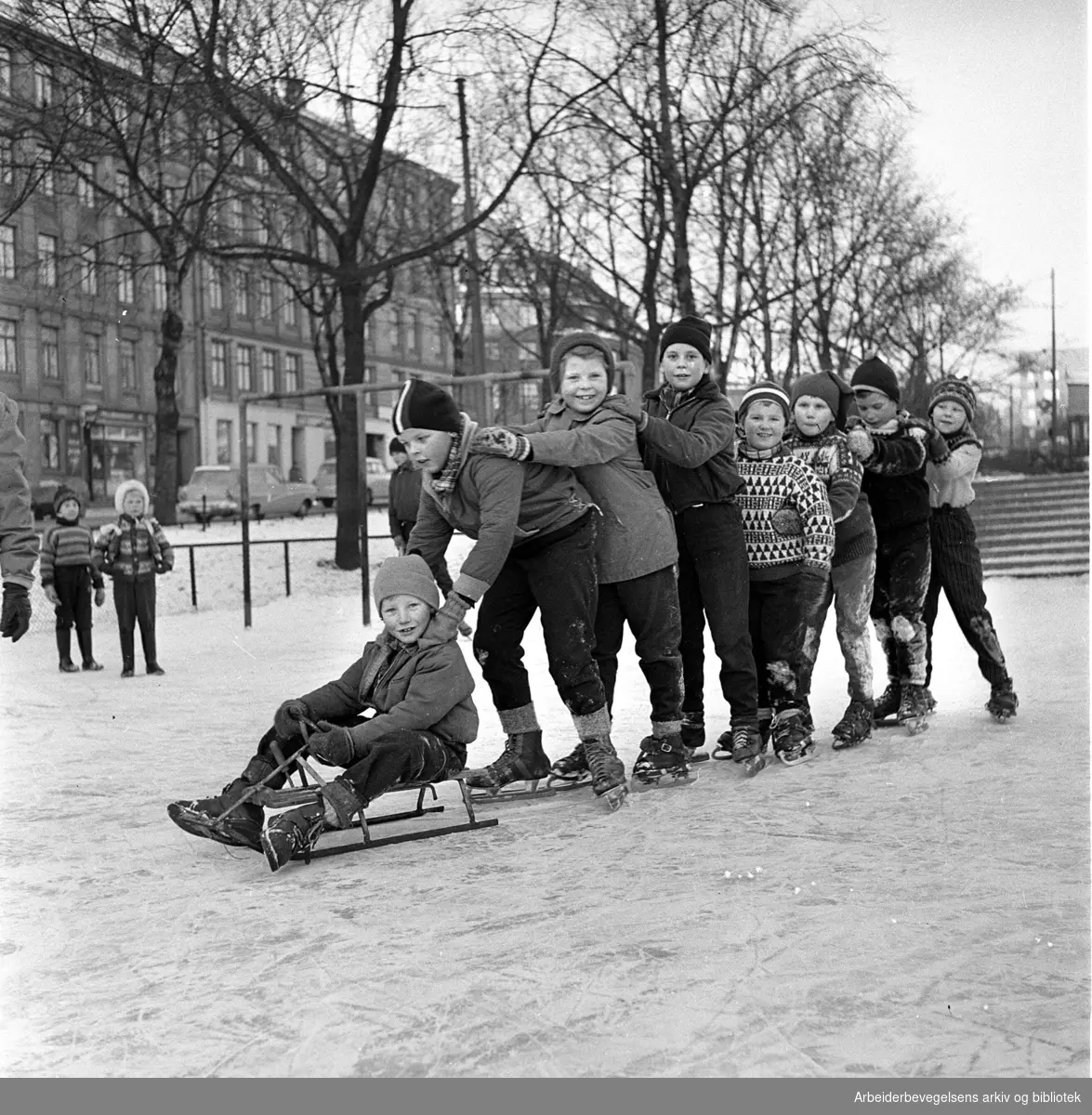 Barn på skøyter og med rattkjelke. Alexander Kiellands plass. Januar 1960