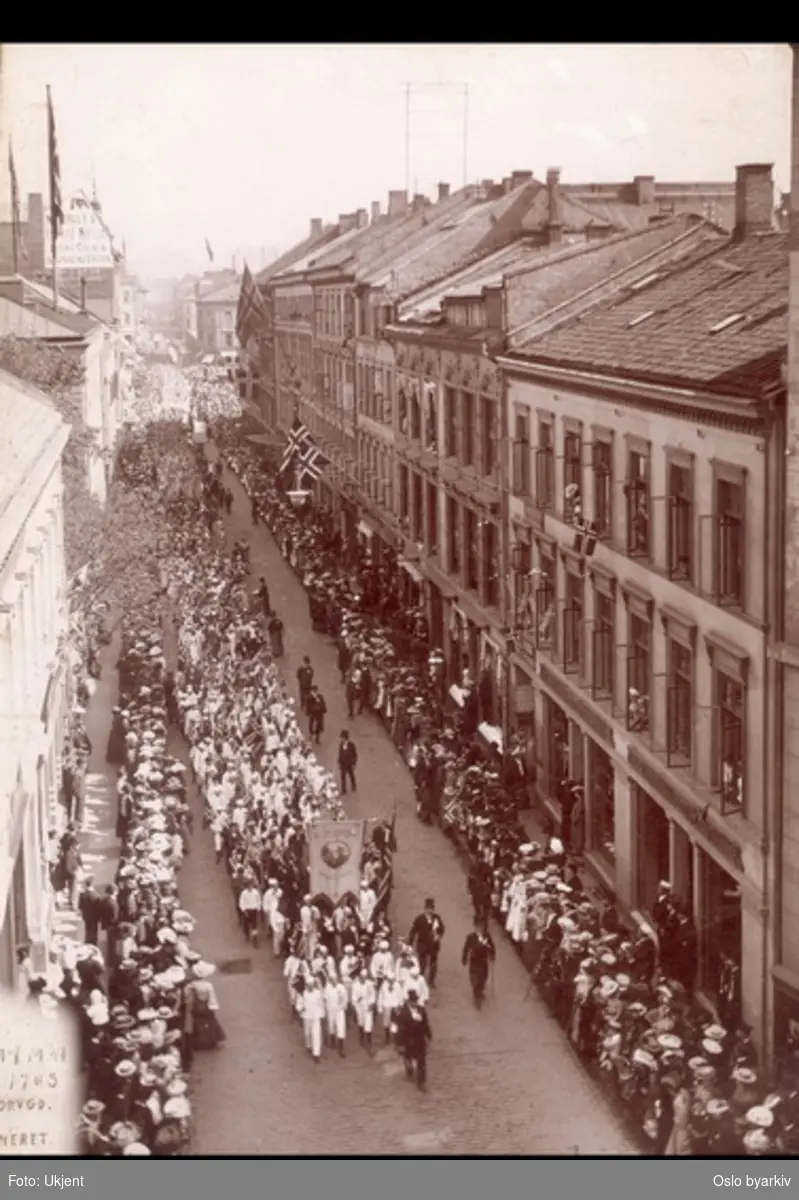 17. mai-tog i Torggata 1905. Barn med flagg. Guttekorps og faner, Menn med flosshatt. Publikum i finstas langs togets rute.