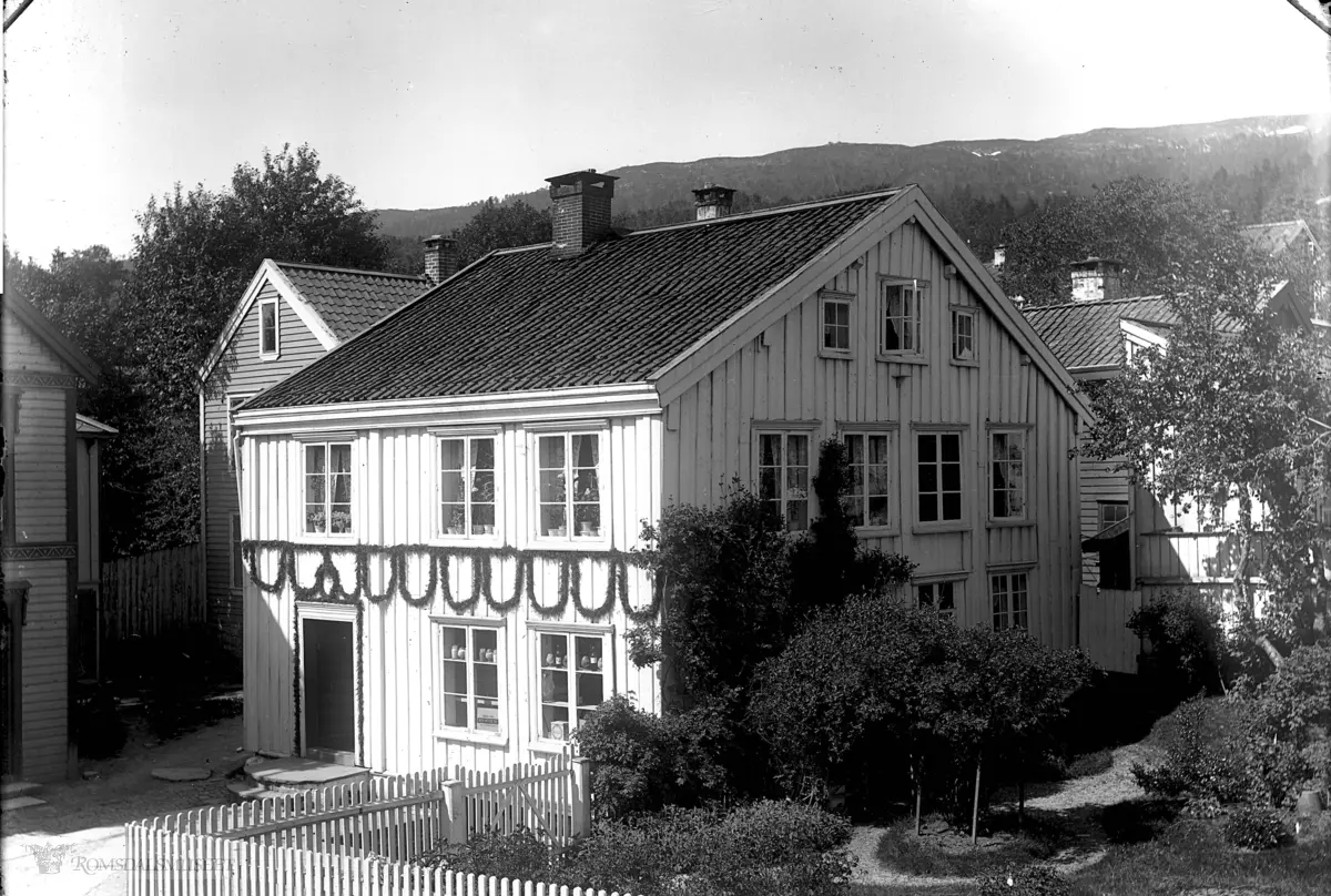 Harald Eide hus med hage som ligger vest for Lovise Lunds hus og rett over gaten for N.P.Dahls hus i Storgata..Vi ser litt av Aandalsgården til venstre.