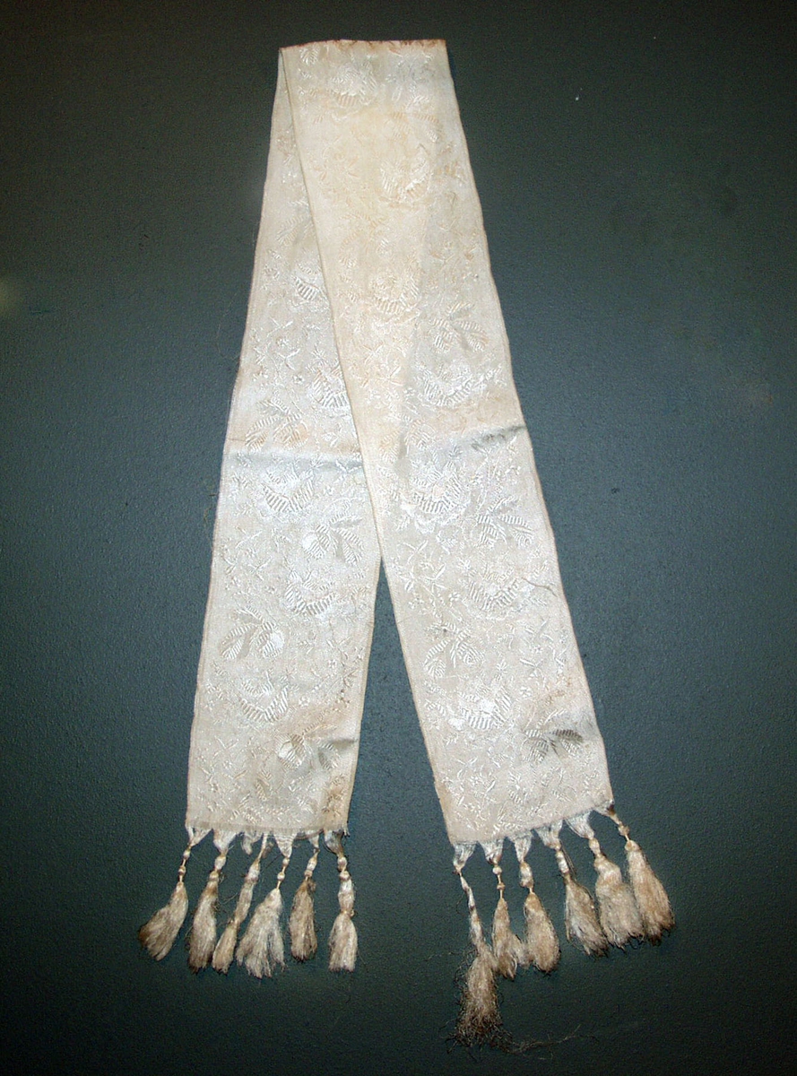 Form: Smalt sjerf, frynsekant 8 cm med snurr. Damaskvevet silke.
