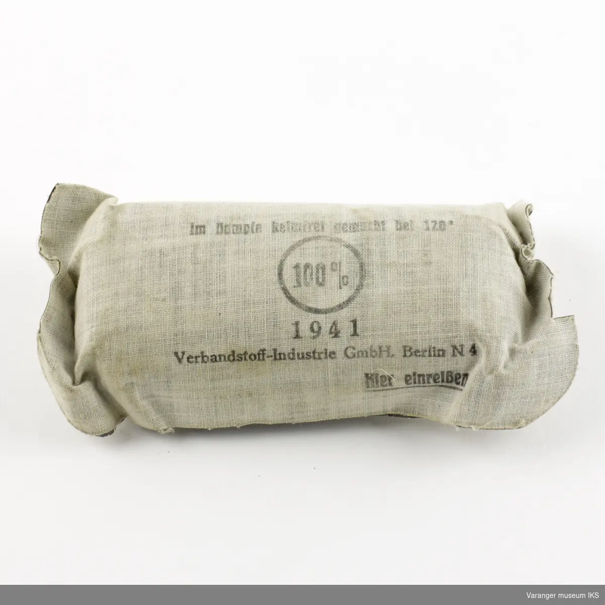 Tysk førstehjelpsutstyr (enmannspakke) fra andre verdenskrig. Ytre emballasje i grått lerretsstoff.