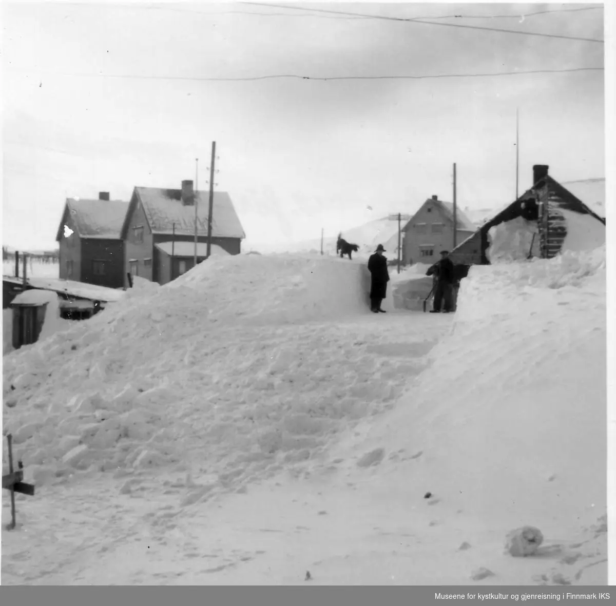 Ordfører Jentofts gate. Fotoet er tatt oppover gata. 4 - 5 m høye snøskavler. Dokumentasjon i rettssak. 1952