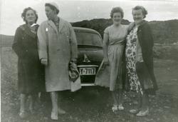fire kvinner står ved en bil på veien