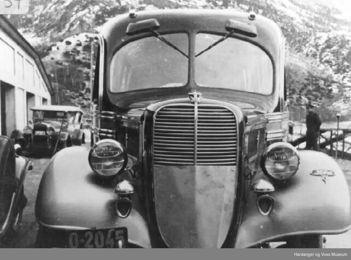 Mann. Buss nr. O-2045 Ford V8 og i bakgrunnen bil nr. R-6016, 1928 Hudson. HSD garasjen