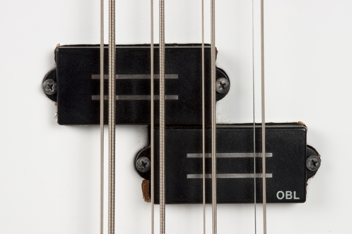 Elektrisk bassgitar med åtte strenger: fire tykke med tilhørende store stemmeskruer og fire tynne med tilhørende mindre stemmeskruer.  To OBL-pickuper.