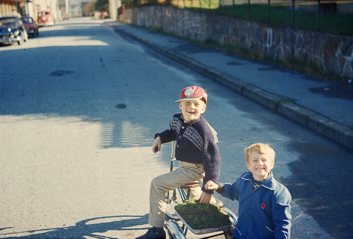 Gutar på trehjulssykkel i ei gate.