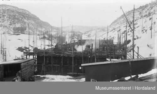 Anleggsplass, støyping av fundament til Herlandsfossen kraftstasjon, forskalingar i trevirke, vinterlandskap