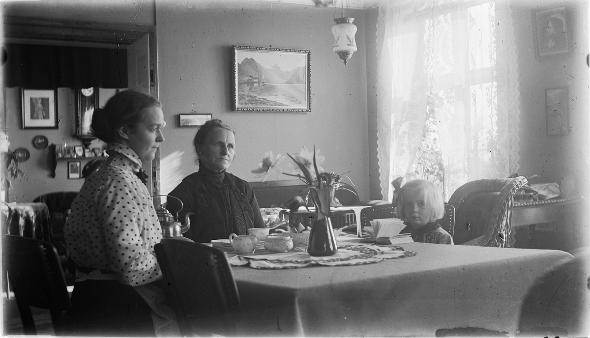 Fra venstre: Aagoth Johannessen, svigermor Lovise Johannessen og Lumi Johannessen. Interiør, stue.




Inteirør, stue. To kvinner og ei jente rundt stuebordet. Kona til Johannessen til venstre.