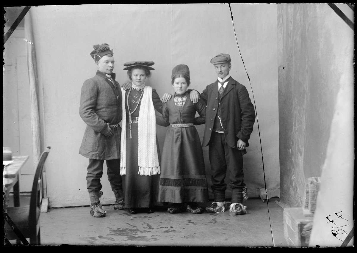 Gruppeportrett av fire personer i samisk drakt