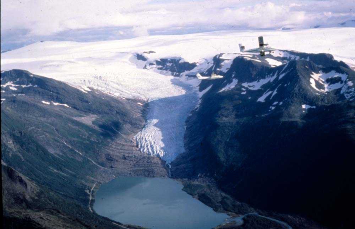 Luftfoto. To fly, LN-BNH DHC-6 og LN-WFG DHC-7 fra Widerøe
passerer Svartisen og Engenbreen