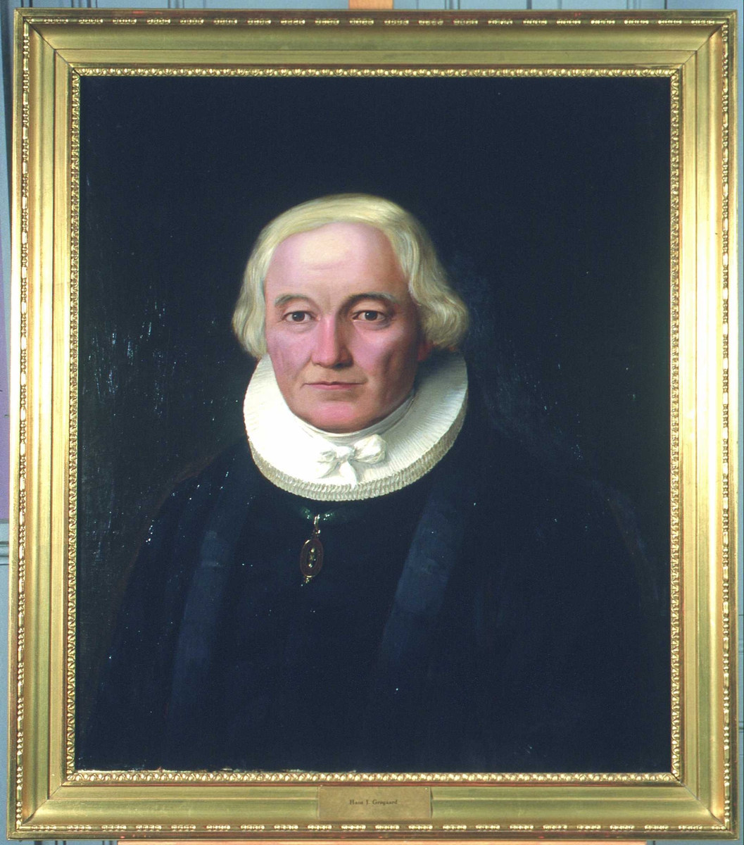 Portrett av Grøgaard (Grøgård). Prestekjole og -krave. Medalje i grønt bånd om halsen.