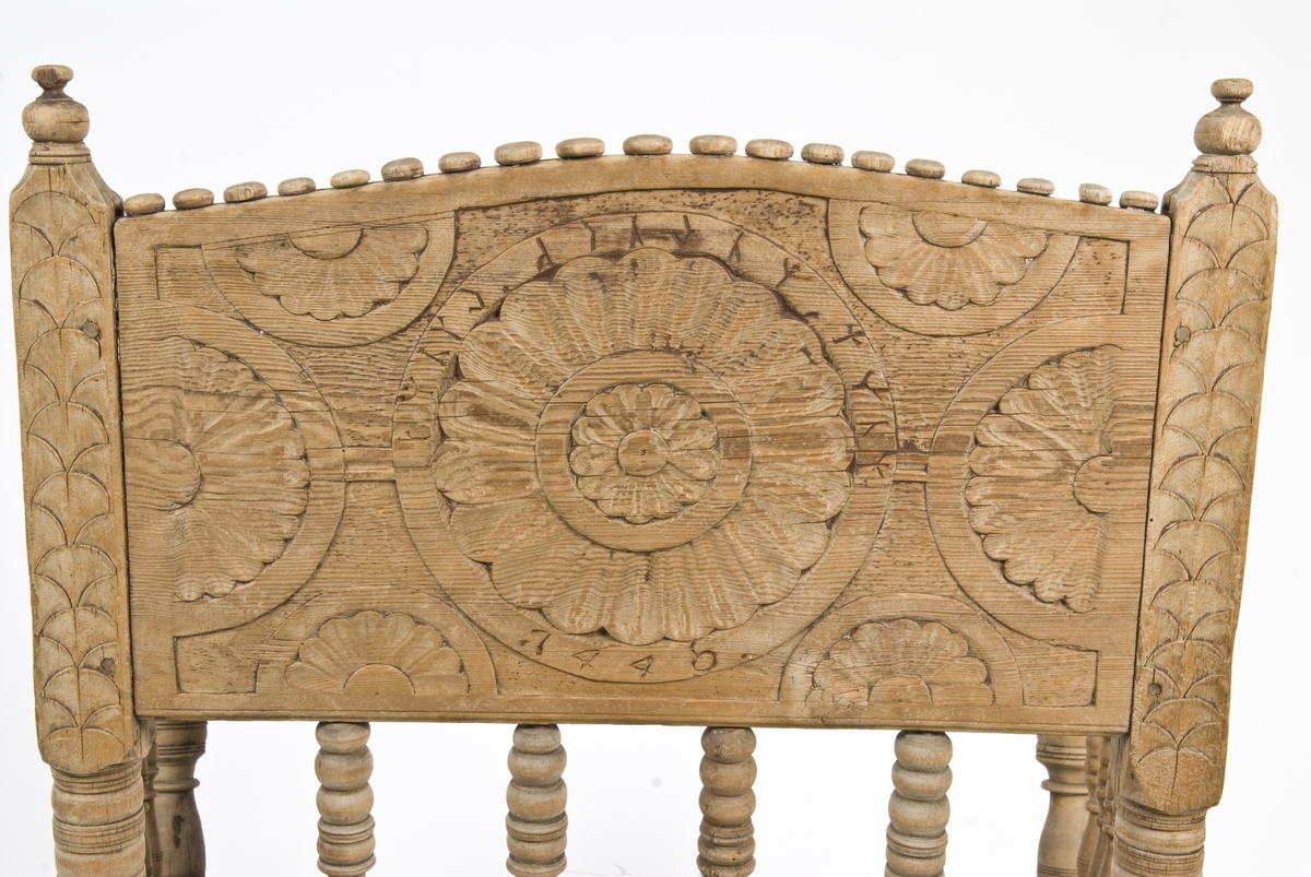 Armstol på kryss fot med mulighet for å snurres. Runeinnskrift skåret inn på ryggen. Dreid og skåret dekor.