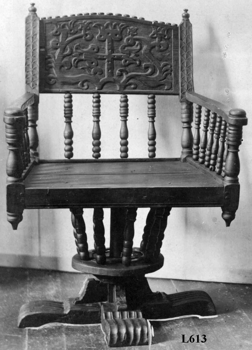 Armstol på kryss fot med mulighet for å snurres. Runeinnskrift skåret inn på ryggen. Dreid og skåret dekor.