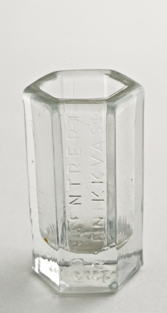 Måleglass i glass. 6-kantet, sylindrisk. Støpt i glasset mengdemålet 15 cm3 og 
10 cm3