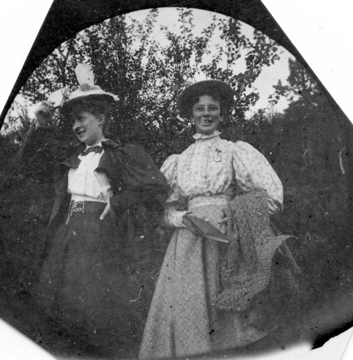 To damer i skogen, ei holder ei bok i hånden.