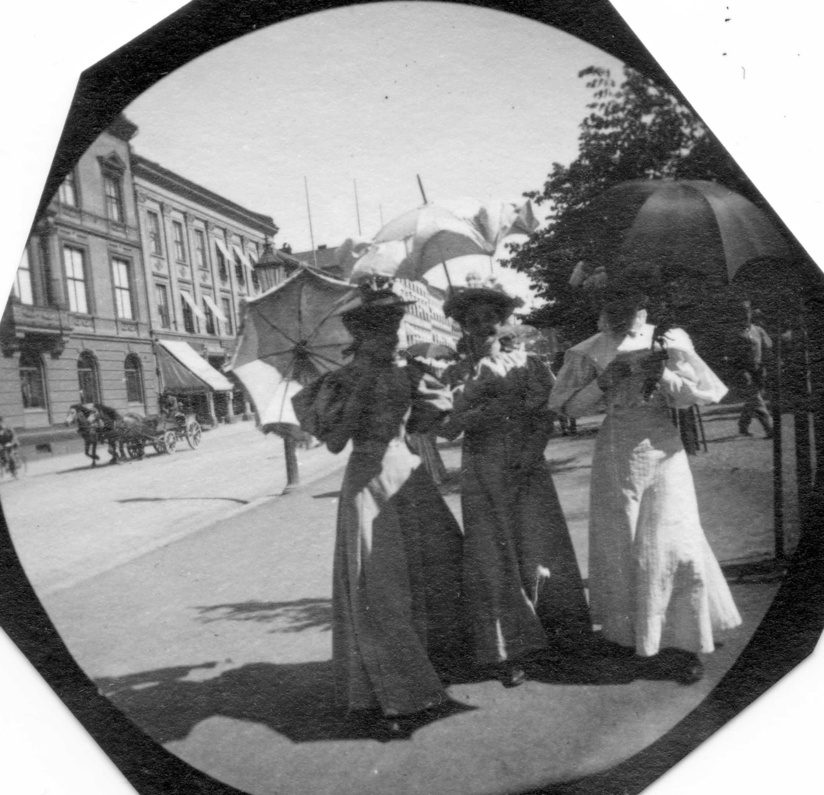 Tre kvinner spaserer langs Karl Johans gate, Oslo. Hestekjøretøy i bakgrunnen. Fra venstre Johanne Irgens, Signe Faye Hansen og frk. Augusta Irgens.
