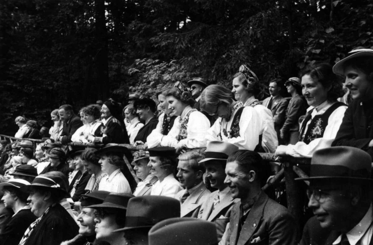 Åpning etter nymontering den 27. juni 1938. Festtaler holdes i Friluftsteateret,NF349. Publikum og ansatte følger med fra tilskuerplassene.