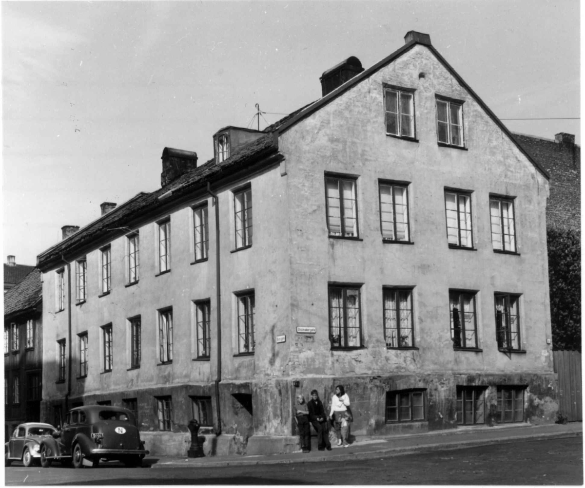 Stolmakergata 8, Oslo 1961. Fasaden, barn står lent mot gatehjørnet, biler parkert ved fortauet.